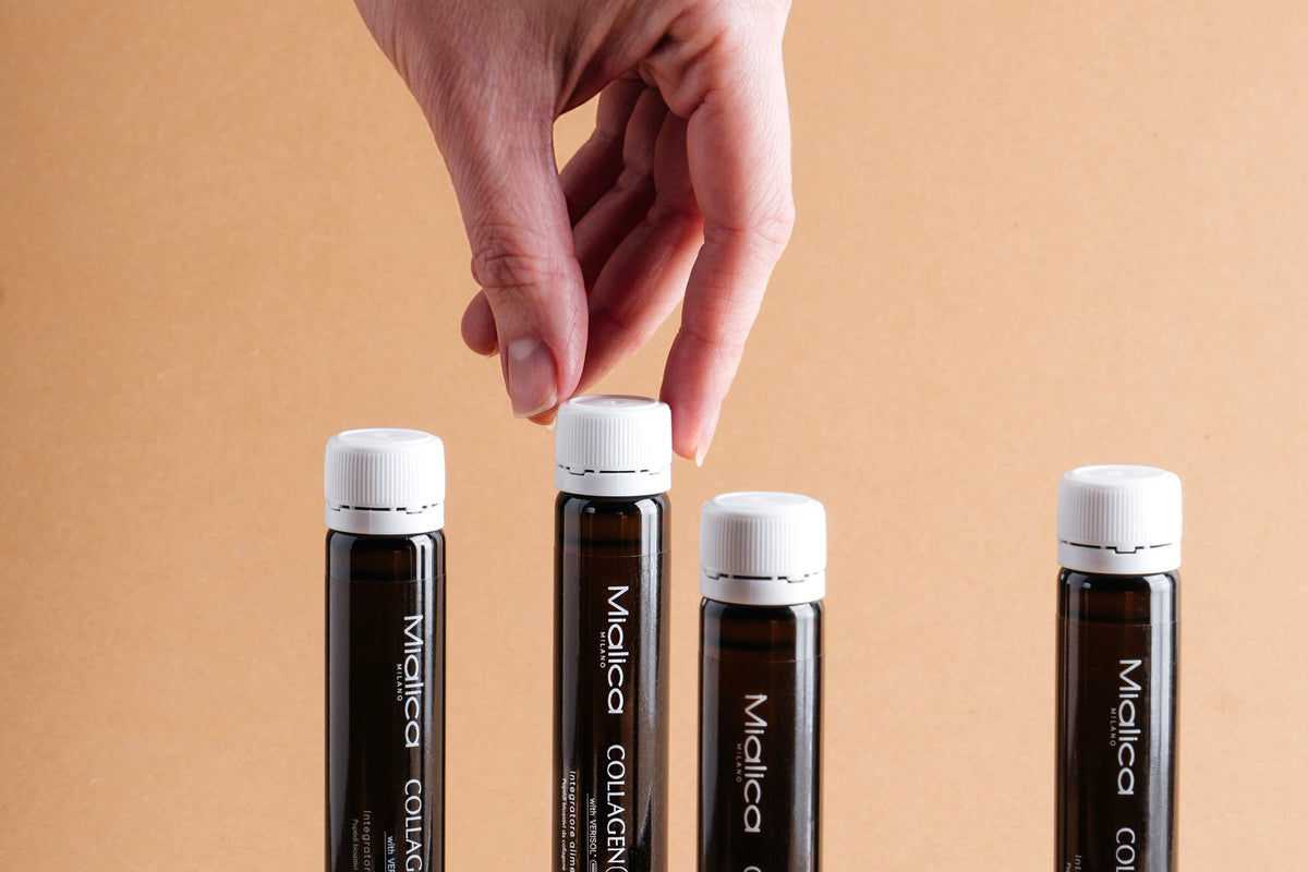 Una mano sceglie una fiala di Collagen PRO5 tra altre fiale