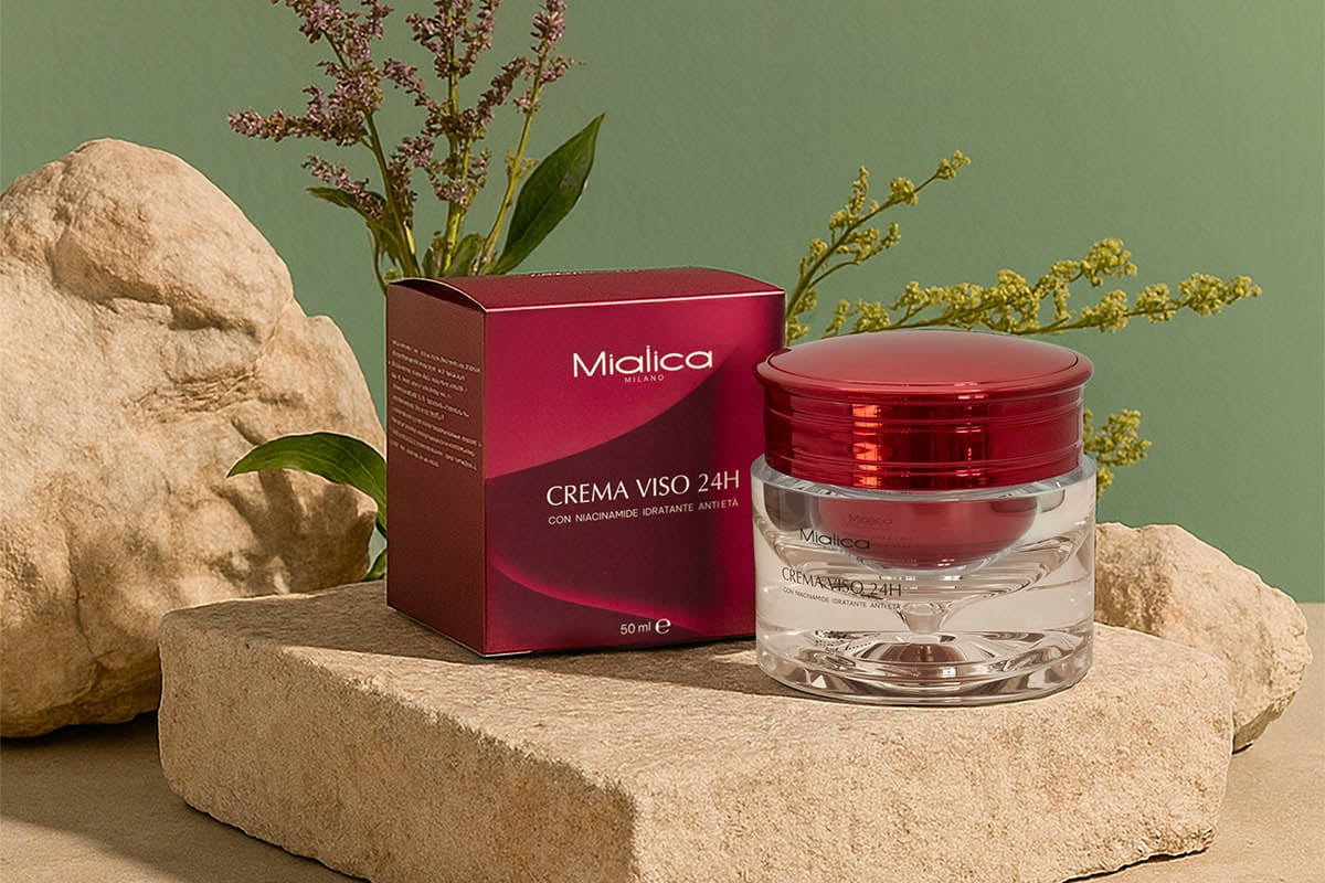 Crema Viso 24H Mialica con la sua confezione su una pietra